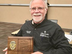 Russ Myers holding plaque