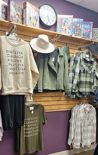 Angel's Attic gift shop display rack of clothing and puzzles