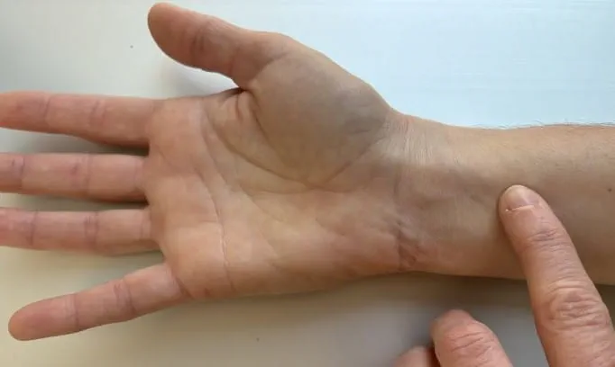 index finger on pressure point about 1 inch below inner wrist