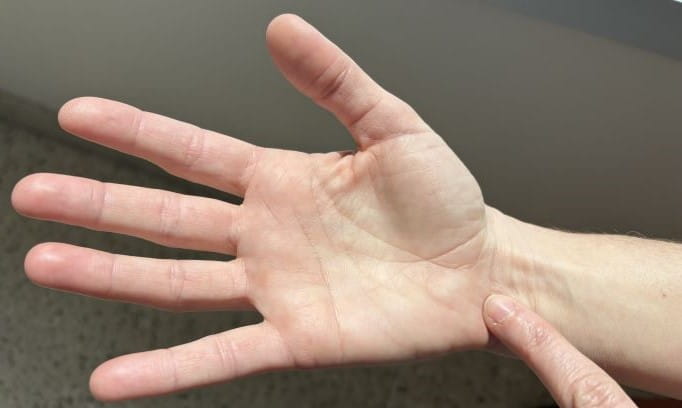 index finger on pressure point at inner wrist crease